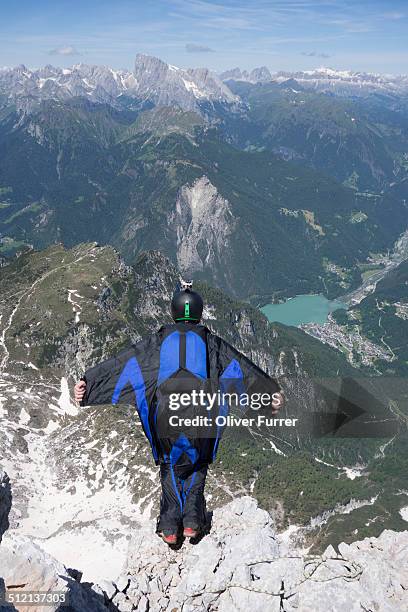 mid adult man base jumping from mountain edge, alleghe, dolomites, italy - base jumping stock pictures, royalty-free photos & images