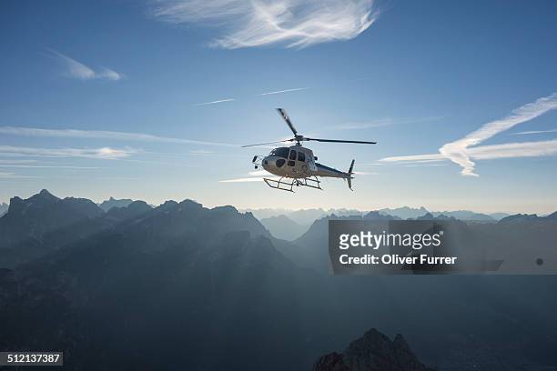 helicopter on scenic flight at sunrise, alleghe, dolomites, italy - helicopter photos et images de collection