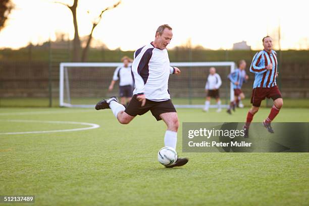 football player kicking ball - amateur football fotografías e imágenes de stock