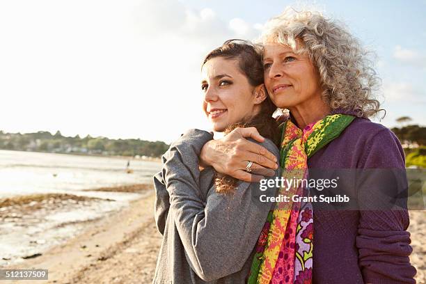 mother and daughter enjoying beach - mature woman daughter stockfoto's en -beelden