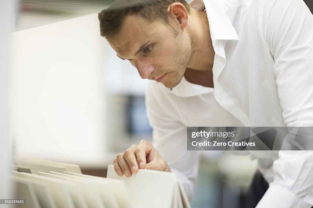 Salesman searching in filing cabinet in kitchen showroom