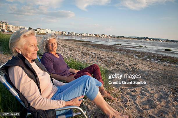 mother and daughter enjoying view on beach - beach town stock pictures, royalty-free photos & images