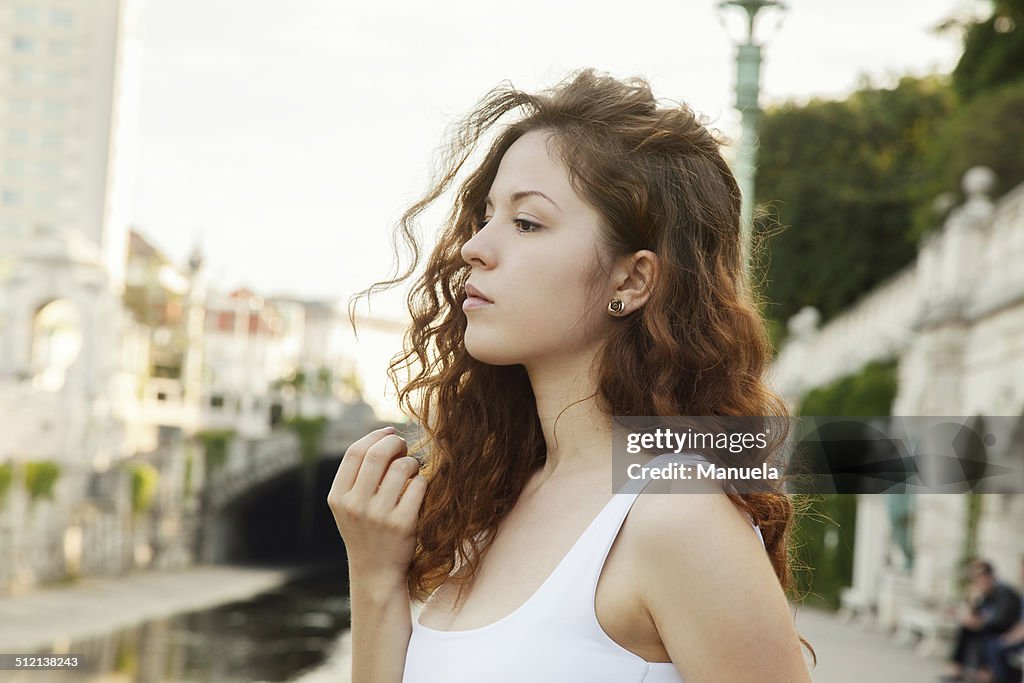Profile portrait of sullen young woman in city