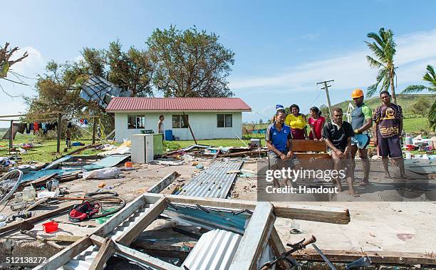 In this handout image supplied by the Mai Life Magazine, the home of Asesela Sadola Fong and his family pose where their house was on February 22,...