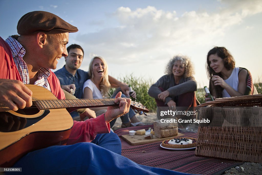 Five adult friends picnicing on Bournemouth beach, Dorset, UK