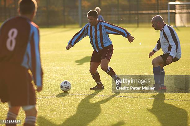 football players running after ball - amateur championship stockfoto's en -beelden