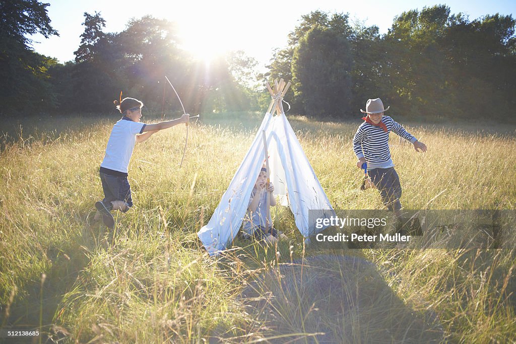 Small group of young boys playing around teepee