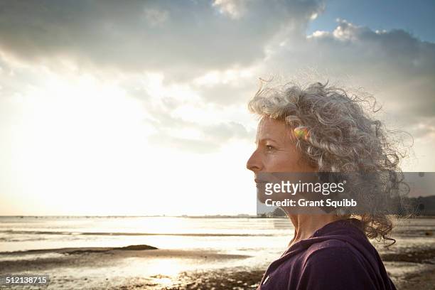 mature woman enjoying beach - mature women serious stock pictures, royalty-free photos & images