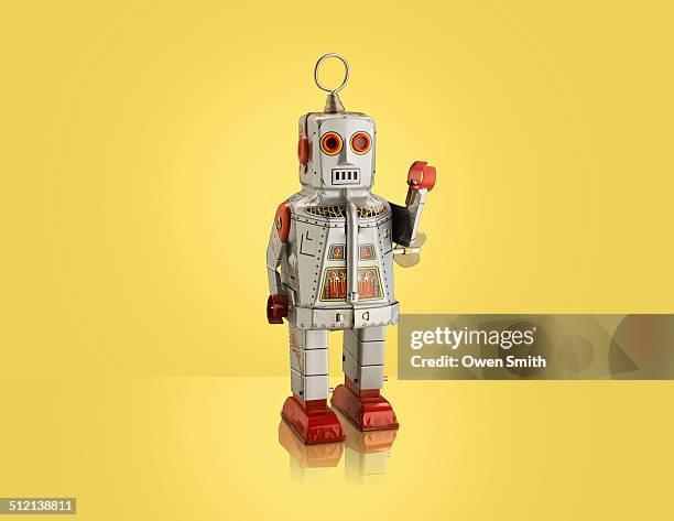 studio shot of silver robot with arm raised - robot funny stock pictures, royalty-free photos & images