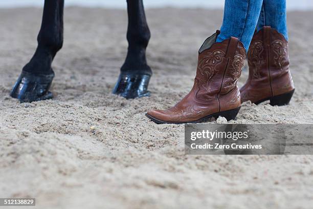 cropped shot of horse hooves and young woman in cowboy boots - cowboystövlar bildbanksfoton och bilder