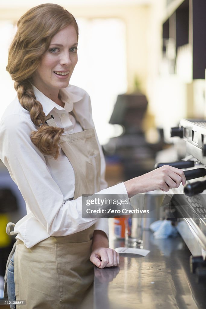 Portrait of waitress using coffee machine in restaurant