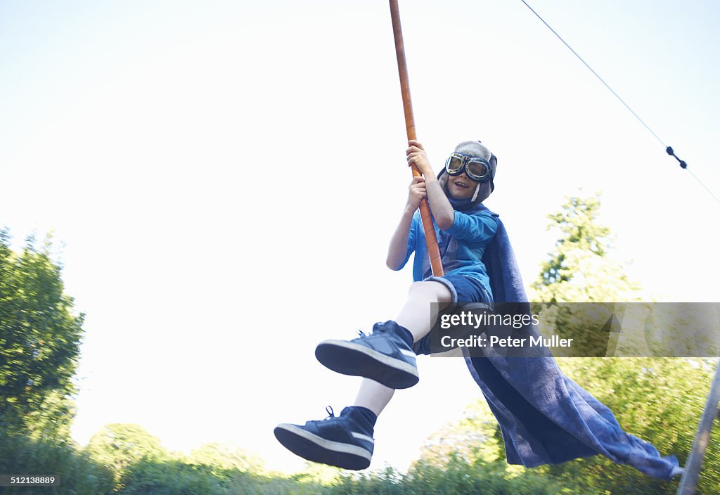 Young boy in fancy dress, on zip wire