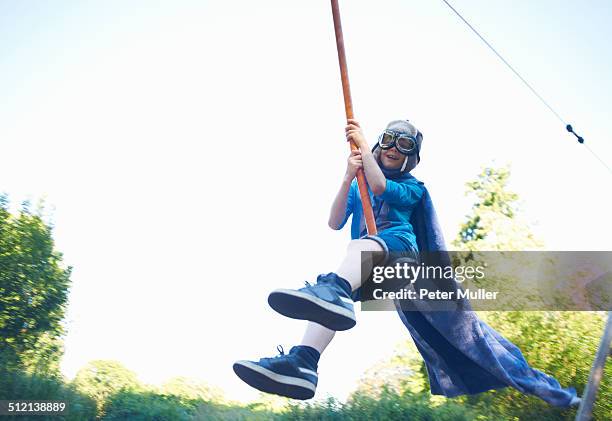 young boy in fancy dress, on zip wire - óculos de aviação - fotografias e filmes do acervo