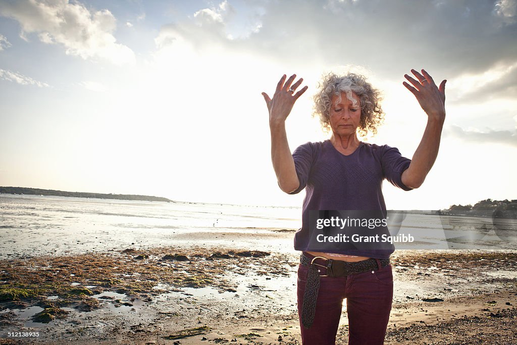 Mature woman exercising on beach