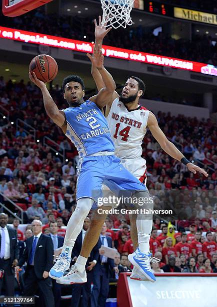 Caleb Martin of the North Carolina State Wolfpack fouls Joel Berry II of the North Carolina Tar Heels during their game at PNC Arena on February 24,...