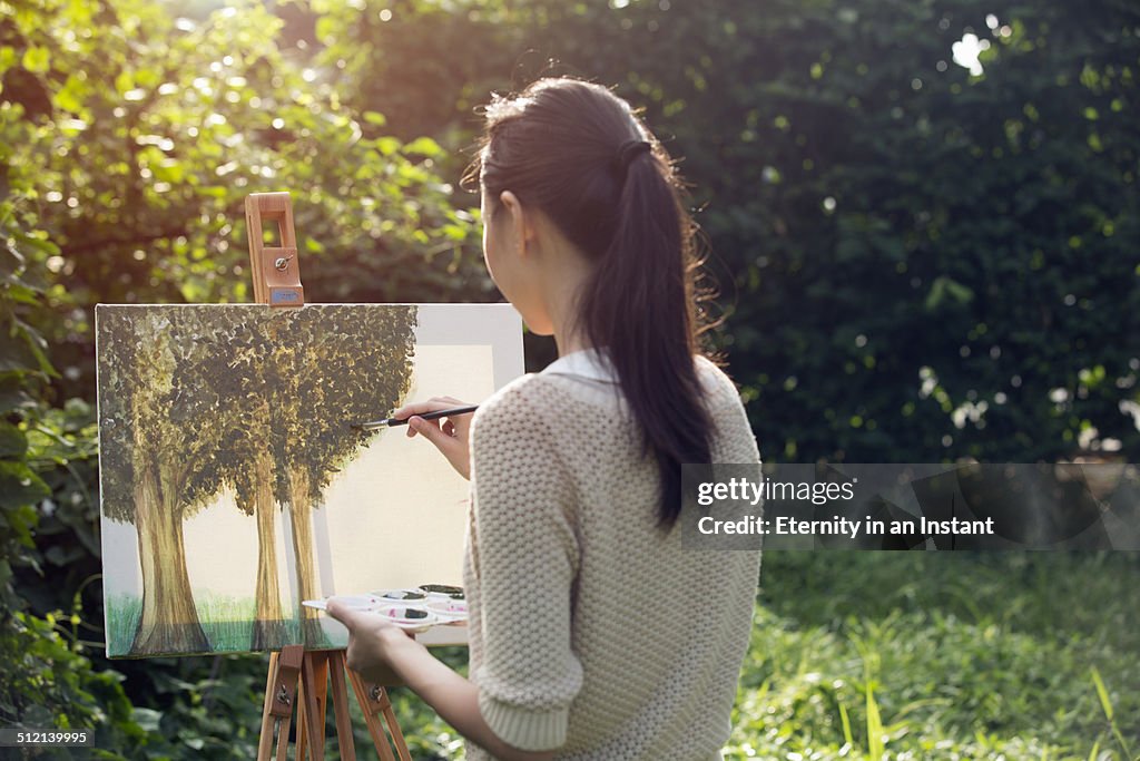 Artist painting trees outdoors