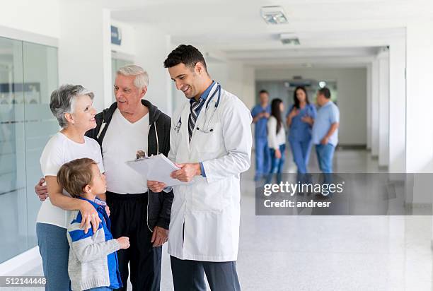 doctor talking to patients at the hospital - family with doctor stock pictures, royalty-free photos & images