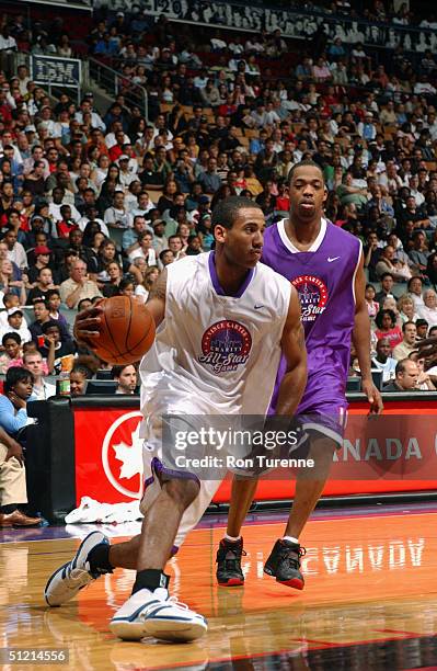 Dahntay Jones of the Memphis Grizzlies drives around Rafer Alston of the Toronto Raptors during the Vince Carter All-Star Charity Game at the Air...