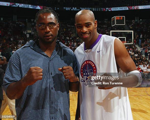 Vince Carter of the Toronto Raptors poses for a portrait with heavyweight boxer Lennox Lewis during the Vince Carter All Star Charity Game at the Air...