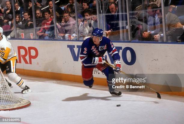 Brian Leetch of the New York Rangers skates around the net with the puck during an NHL game against the Pittsburgh Penguins on February 5, 1992 at...