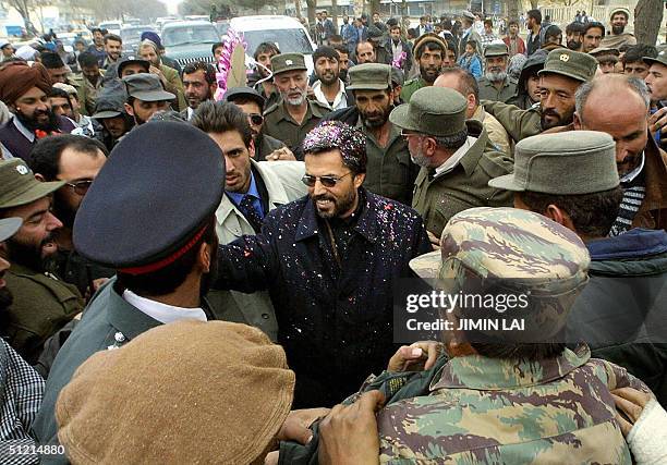 In this picture taken 12 December 2001, Afghanistan's designated interior minister, Yunus Qanooni meets with local Afghans on a main street in Kabul....