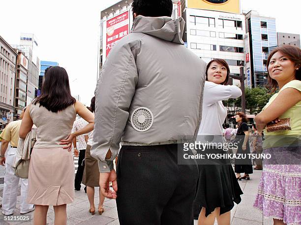 Man wears a jacket with two built-in electric fans to keep cool on his body at downtonw Tokyo 25 August 2004. Japanese venture PC2B, established by...