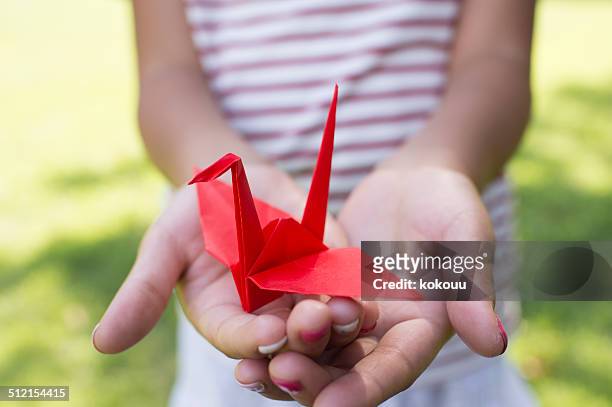 girl holding a paper crane - origami stock pictures, royalty-free photos & images