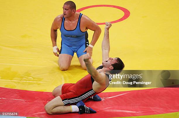 Georgiy Tsurtsumia of Kazakhstan celebrates as he defeats Rulon Gardner of the USA during the men's Greco-Roman wrestling 120 kg semifinal round on...