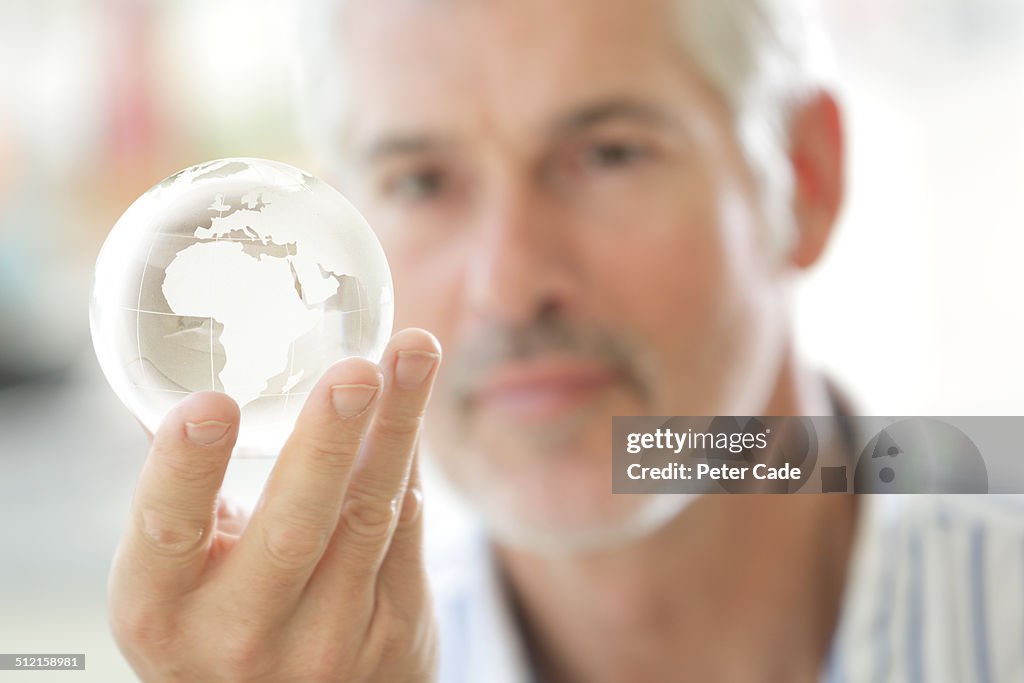 Man looking at glass globe
