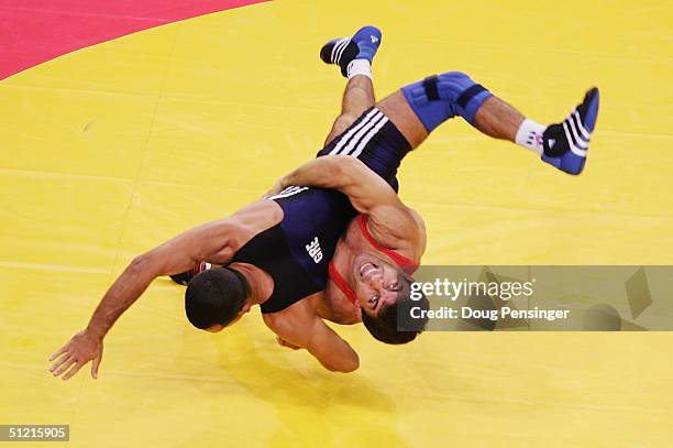 Gueidar Mamedaliev of Russia in red takes down Artiom Kiouregkian of Greece as Mamedaliev took the win during the men's Greco-Roman wrestling 55 kg...