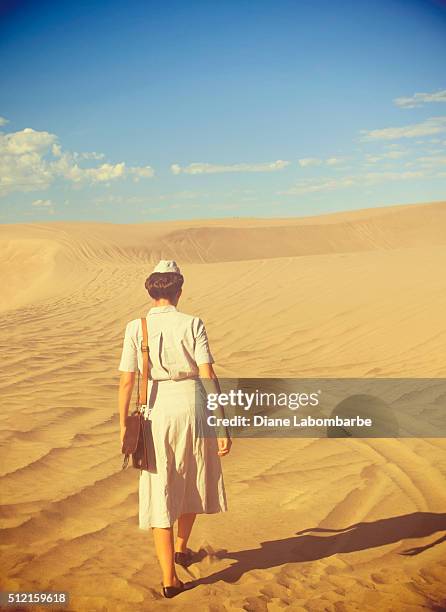 wwii nurse walking away from the camera in the desert - tweede wereldoorlog stockfoto's en -beelden