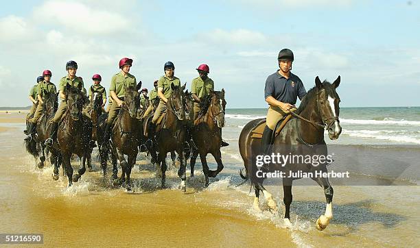 Members of The Household Cavalry Mounted Regiment take time out from their ceremonial duty to give their horses a training break on the sands at...