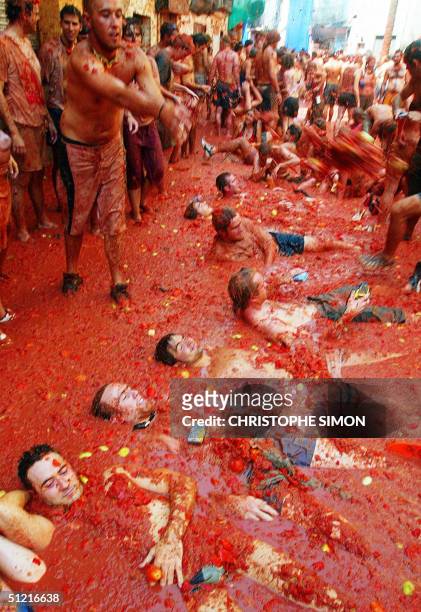 People wallow in tomato juice during the "Tomatina", a traditional festival where people throw tomatoes at each other in Buniol, 300 km east of...
