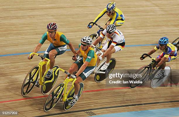 Graeme Brown assists teammate Stuart O'Grady of Australia in the men's track cycling madison final on August 25, 2004 during the Athens 2004 Summer...