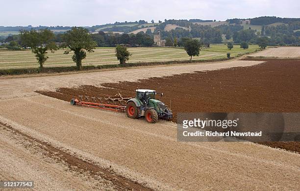 tractor ploughing field - plowing stock pictures, royalty-free photos & images