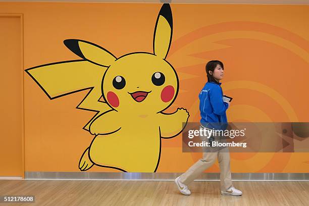 An employee walks past a wall featuring the Pikachu character at the Pokemon Center Mega Tokyo store in Tokyo, Japan, on Wednesday, Feb. 24, 2016....