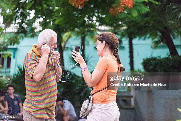 Daughter and father, generation gap, using wifi internet in public area to connect with family abroad.