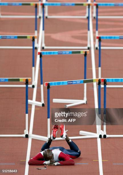 Allen Johnson of the USA lies on the track after he crashed out in the men's 110m hurdles round two, heat two, 25 August 2004, during the Olympic...