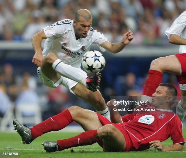 French Real Madrid player Zinedine Zidane fights for the ball with Wisla Krakow's Klos during their champions league football match in Santigo...