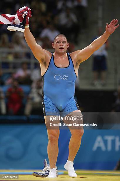 Rulon Gardner of the USA celebrates winning as he walks off the mat leaving his shoes behindto signfy his retirement after winning the bronze medal...