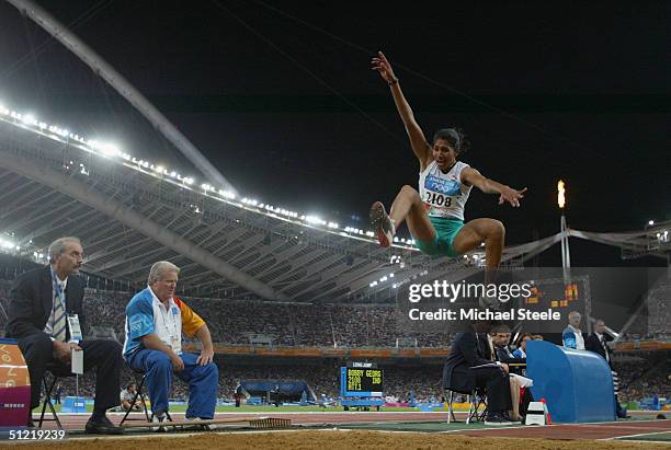 Anju Bobby George of India competes infront of the Olympic flame in the women's long jump qualifying round on August 25, 2004 during the Athens 2004...