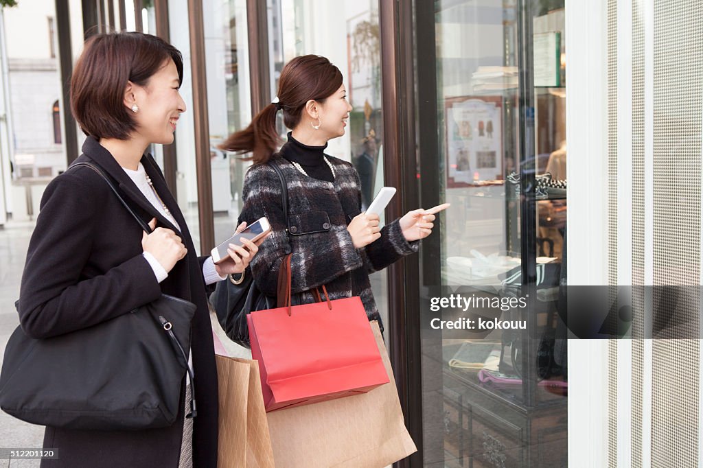 女性が見られる、ショップのウィンドウにお尋ねください。