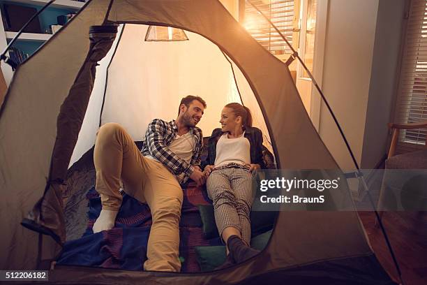 young smiling couple relaxing in a tent at home. - inside of tent stock pictures, royalty-free photos & images