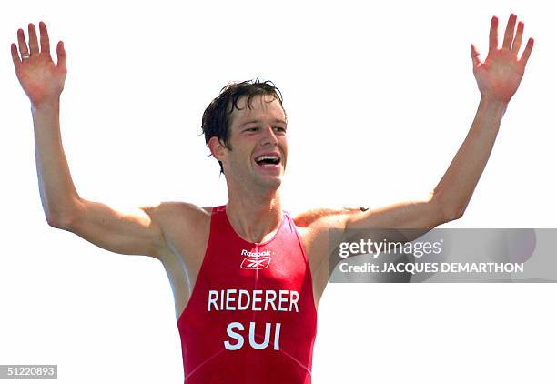 Switzerland's Sven Riederer jubilates on the finish line in the men's Triathlon at the Olympic Games, 26 August 2004 in Athens. New-Zealand's Hamish...