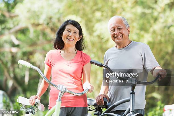 asian couple riding bicycles - japanese senior couple stockfoto's en -beelden