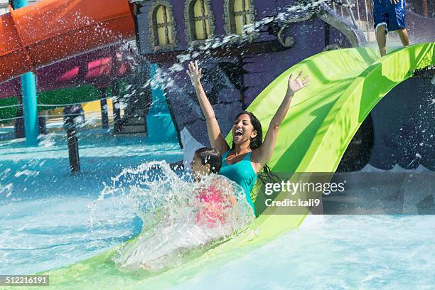 mother and daughter on water slide - waterpark stockfoto's en -beelden