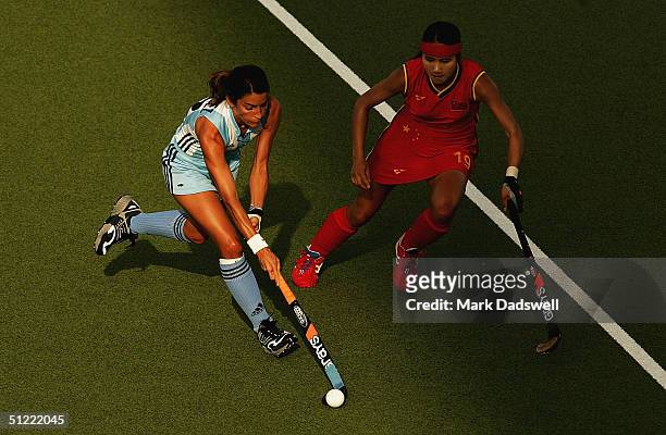 Mariana Gonzalez Oliva of Argentina plays the ball away from Qiuqi Chen of China in the women's field hockey bronze medal match on August 26, 2004...