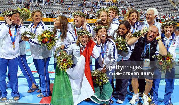 Italy's waterpolo team poses on the podium after winning the women's gold medal match against Greece at the Olympic aquatic center at the 2004...