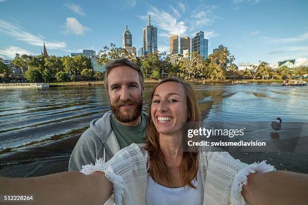 cheerful young couple in melbourne take a selfie portrait - yarra river stockfoto's en -beelden