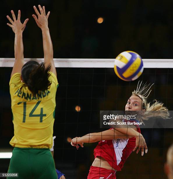 Lioubov Shashkova hits the ball past Fernanda Venturini of Brazil during the Brazil v Russia women's indoor Volleyball semifinal match on August 26,...